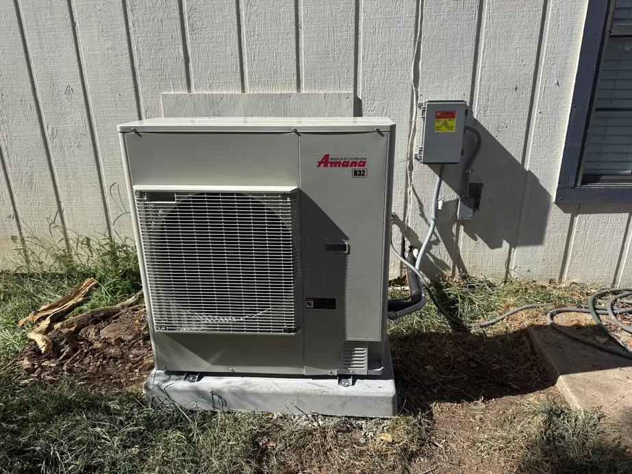 A heat pump outdoor unit installed by Anderson Air on a level pad with a new disconnect